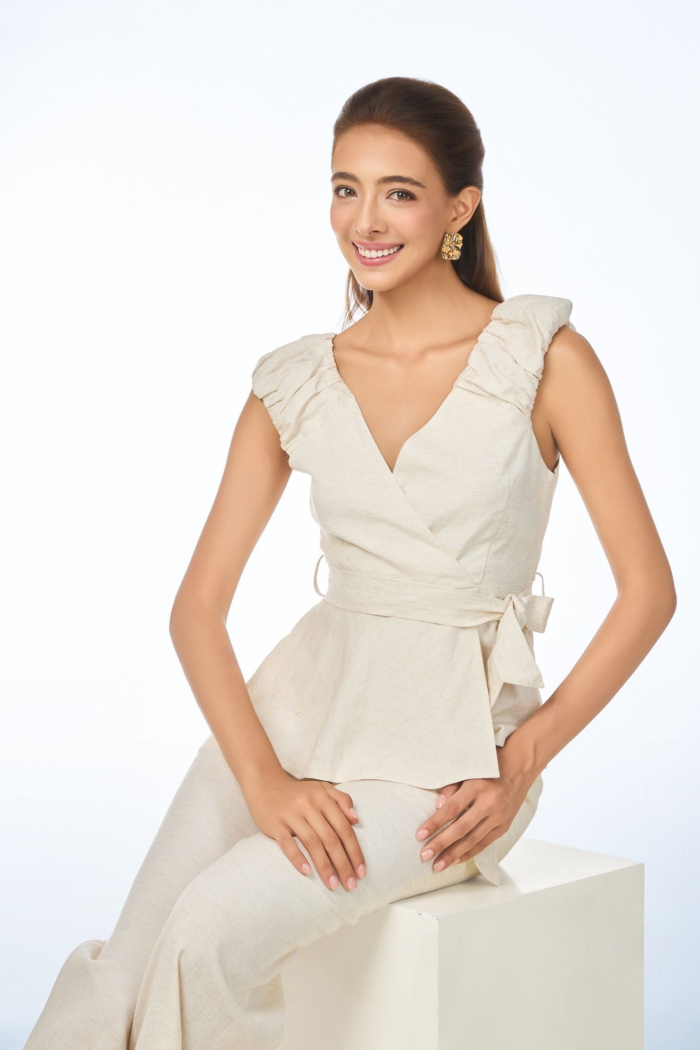 Model wearing the Wonder Shirt in mint green by Vanda Modes, featuring a Vanda's signature Orchid motif collar and front pocket, styled with matching bottoms against a warm beige backdrop.