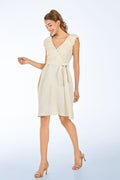 Woman wearing a cream-colored pure linen wrap dress on a light blue background from vandamod designer fashion singapore