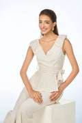 Woman wearing a beige sleeveless top with ruffled details on a white background from vanda fashion singapore
