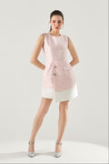 Woman wearing a pink sleeveless Blush Authority Tafetta dress from VandaMod on a light gray background