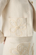 Beige fabric with embroidered floral patterns on a plain background of Elise Braided Tweed Blazer at Vandamod