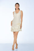 Woman wearing a white sleeveless dress with floral details on a light blue background from vanda fashion design singapore