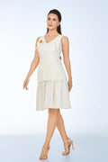 Woman wearing a white dress with hand-smocked detail on a light blue background from vandamod designer fashion sg